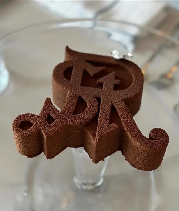 Monogramme en chocolat, finition velours, posé sur un pied en verre