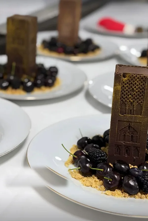 Tour Hassan en chocolat sur une assiette de cerises et de crumble